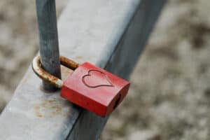 closeup-shot-metal-padlock-with-heart-hanging-fence